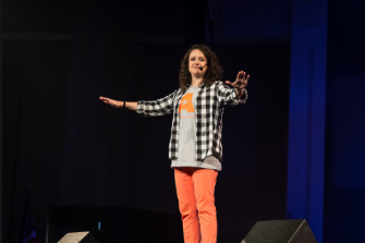 Photo of Christen clark speaking on stage - COllide Kids Podcast